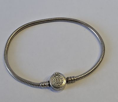 gros plan d'un bracelet en argent sur une surface blanche