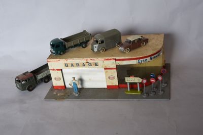 a model of a gas station with cars and a truck