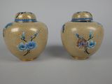 pair of blue and yellow vases with flowers painted on them