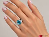 an image of a woman ' s hand with a ring with a blue topaz stone