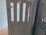 a dog gate in the corner of a room with a green carpet