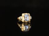 an image of a gold ring with a blue topaz stone