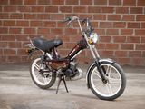 a small motorcycle parked in front of a brick wall