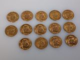 a close up of a bunch of gold coins on a white surface