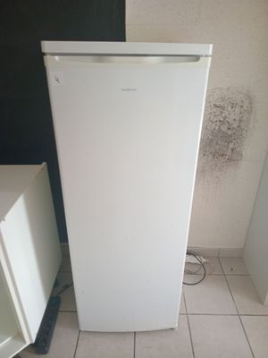 a white refrigerator sitting in the corner of a room