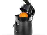 une orange que l'on presse dans un presse-agrumes muni d'une poignée noire