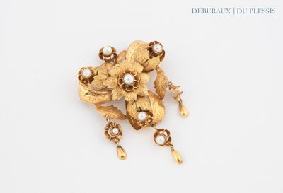 an image of a gold flower brooch with pearls on a white surface