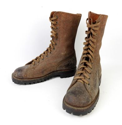 une paire de bottes en cuir marron à lacets sur fond blanc