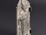 an old silver statue of a man with a hat and a robe