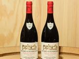 deux bouteilles de vin rouge posées sur un tonneau