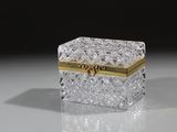 boîte en cristal posée sur une surface réfléchissante avec un fond noir