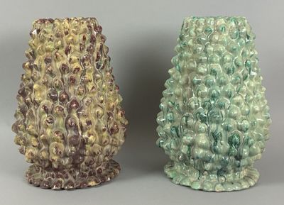 two vases sitting side by side on a gray surface