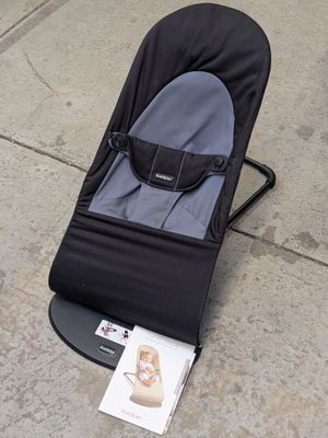 un bébé dans une poussette sur le trottoir, à côté d'un magazine