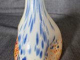 a white vase with a blue and orange design on it