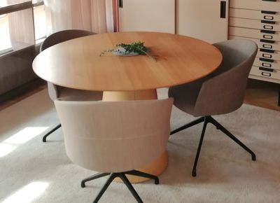 a table with chairs and a vase on it in a room