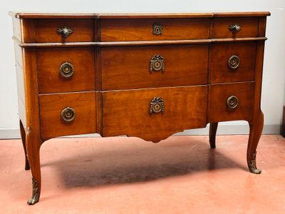 a wooden chest of drawers with brass knobs on it