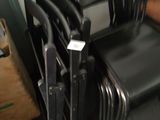 a lot of chairs that are stacked up in a room