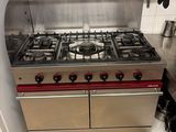 a stainless steel stove top in a kitchen with pots and pans on it