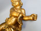 une statue en or représentant un bébé assis sur une table