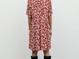the back view of a woman in a floral dress and knee high boots