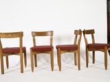 three wooden chairs sitting next to each other on a white surface
