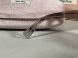 someone is holding a pink purse with a pair of sunglasses on top of it