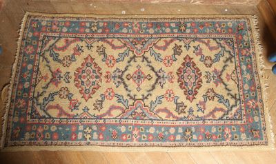un gros plan d'un tapis posé sur un parquet, à côté d'une paire de ciseaux