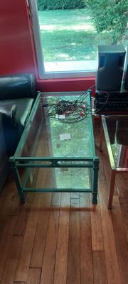 une table en verre sur laquelle est posé un ordinateur portable, dans le salon