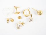plusieurs paires de boucles d'oreilles et de bagues posées sur une surface blanche