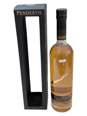 a bottle of penderyn whisky next to a black box