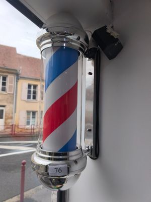 un mât rayé de rouge, de blanc et de bleu fixé à un mur