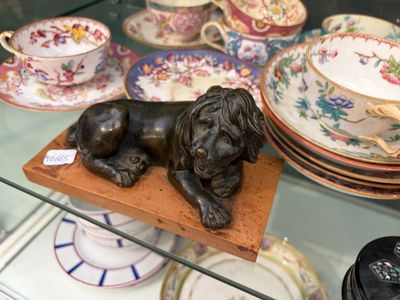 une statue représentant un chien couché sur une assiette