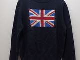 Le pull est orné d'un drapeau britannique et est suspendu à un cintre.
