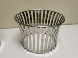 a silver basket sitting on a table next to a toothbrush