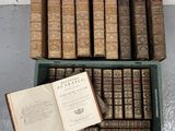 un livre ouvert posé sur une boîte verte à côté d'une pile de livres