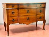 une commode en bois surmontée d'un miroir