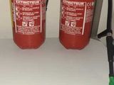 two fire extinguisors sitting on a shelf next to each other