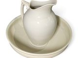 a white pitcher and saucer sitting on a saucer