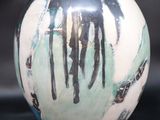 a black and white vase with a painting on it
