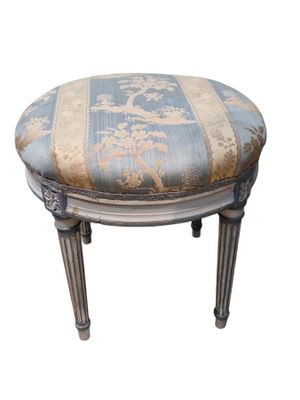 une image représentant un petit tabouret dont l'assise est recouverte d'un tissu bleu et blanc
