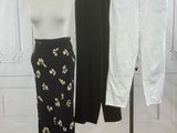 a mannequin and pants on a rack in front of a wall