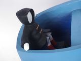 a small figurine of a person sitting in a blue bowl