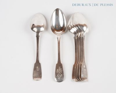 trois cuillères et deux cuillères en argent sur une surface blanche