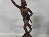 statue en bronze représentant un homme tenant une couronne, posée sur un socle