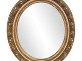 a round mirror with a gold frame on a white background