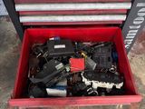 a red tool box filled with assorted tools sitting on top of a floor