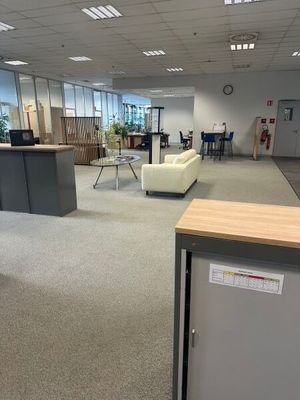 une photo d'un bureau avec un réfrigérateur et une table