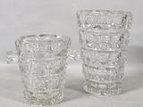 two clear glass vases sitting next to each other on a white surface