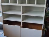 a close up of a white book shelf with two drawers