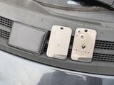 two cell phones that are sitting on the hood of a car